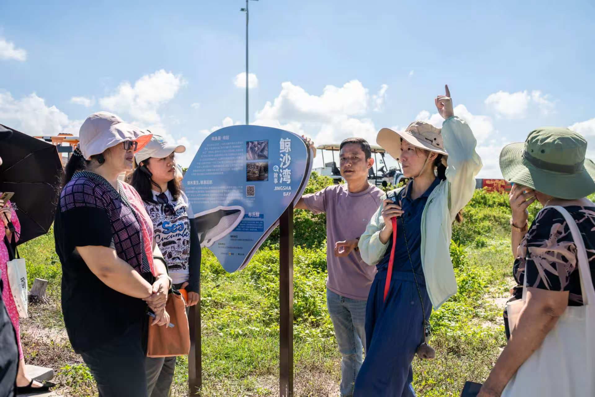 Educational tour at Jingsha Bay with marine conservation signage